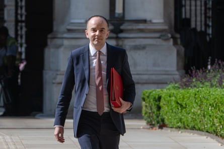 James Murray walking outdoors with folder