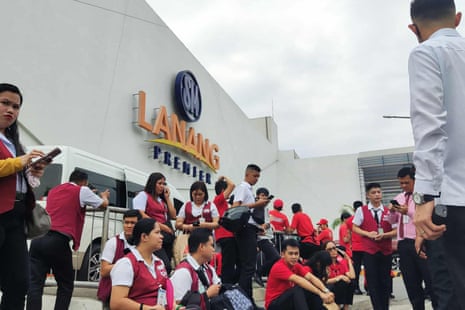 Employees at a shopping mall gather outside the building in Davao City, on the southern island of Mindanao after the earthquake