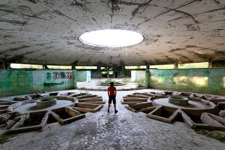 Boy standing by empty pools in the Bathhouse No 6, old abandoned baths in Tskaltubo, Georgia.