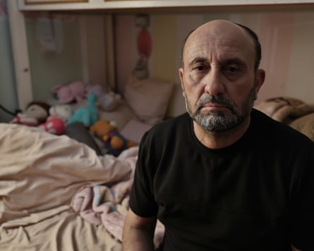 Bassam al-Khatib sitting in a bed by a duvet and children’s soft toys