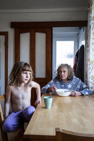 Untitled 5, 2021, by Helen Rimell From the series No Longer Her(e) with Rimell’s niece and mother. Both sitters are physically present in this image, yet her mother’s gaze suggests an absence, a sense of being unable to engage with her surroundings. The series, which began following her mother’s diagnosis of dementia, contemplates presence and the loss of presence, as well as the relationship between daughter and mother. The photographer refers to the complex process ‘of preserving her, of keeping who she was alive’