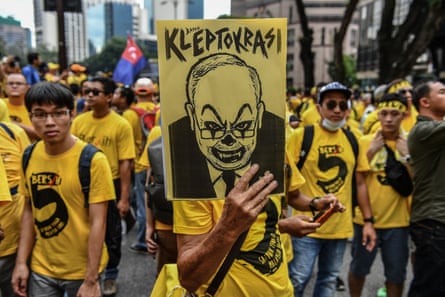 A protester holds a placard with a caricature depicting Malaysian Prime Minister Najib Razak during a mass rally calling for Razak’s resignation, in Kuala Lumpur