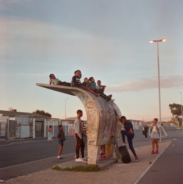 A group of children sitting on top of a bus stop
