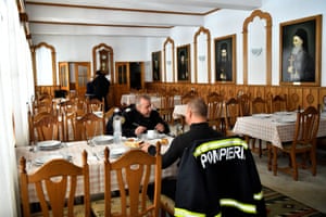 Firefighters eat lunch at Putna Monastery where they are staying while working on the Siret border in Putna, Romania, 11 March. The firefighters have travelled from all over Romania to help and the Monks at Putna Monastery, which is housing people fleeing Ukraine amid Russia’s invasion, are offering bed and board for free