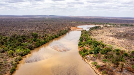 Aerial position of a stream moving done level onshore pinch scrubby bush
