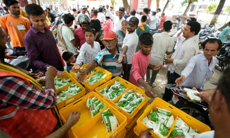 A group of people cold distribute buttermilk outside a polling station as the heat wave continues to grip the northern India during the last round of a six-week-long national election in Varanasi, India, Saturday, 1 June 2024.
