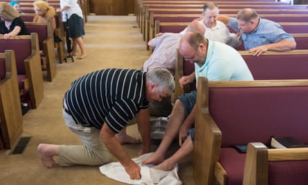 man washes another man's feet in church