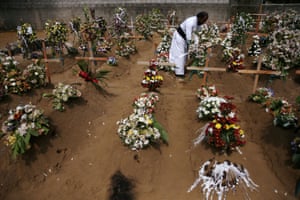 A priest arranges flowers at the site of a mass burial in Negombo.