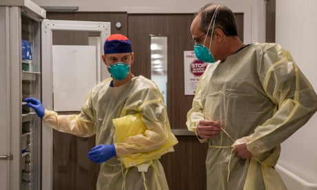 Matt Robinson and Bobby Bluford put on PPE before entering the Covid isolation unit at Methodist University hospital in Memphis. 