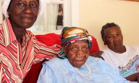 The world’s oldest person Violet Brown sitting with a care giver either side of her at her home in Jamaica