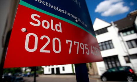 Estate agents signs advertising a residential property as sold stands in London