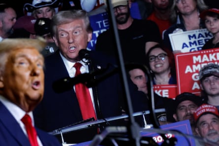 a man in a suit and tie speaks to an arena full of people