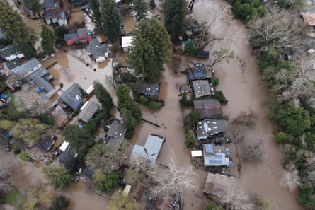 An aerial view of the swollen San Lorenzo River area including homes