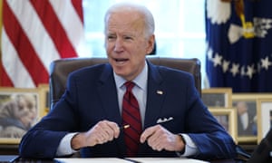 Joe Biden signs a series of executive orders in the Oval Office of the White House in Washington on 28 January 2021.
