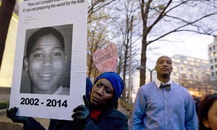 Tomiko Shine holds up a poster of Tamir Rice during a protest in Washington in 2014.