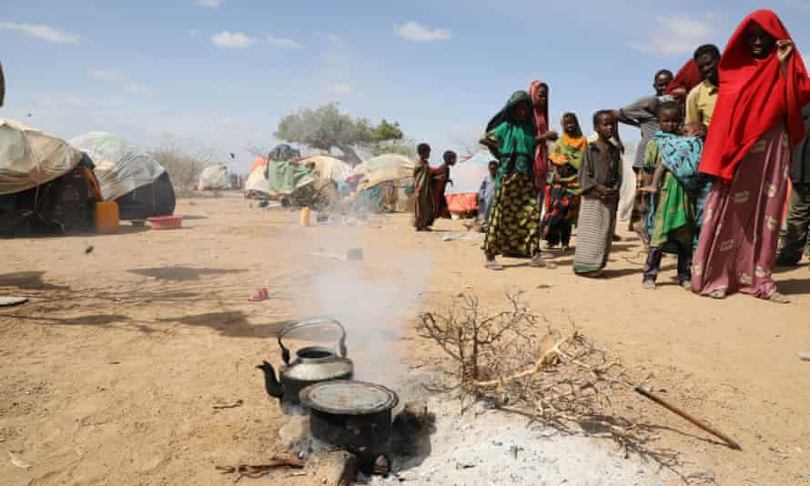 cooking pots and refugees inside a camp 