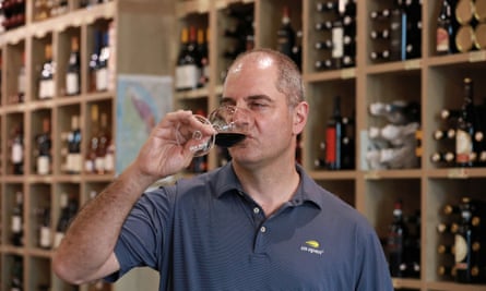 Andre Suidan tastes a glass of red wine in his shop