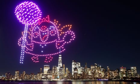 A character holding a lollipop is created by 500 drones over the skyline of lower Manhattan during an advertising promotion for the video game Candy Crush Saga.