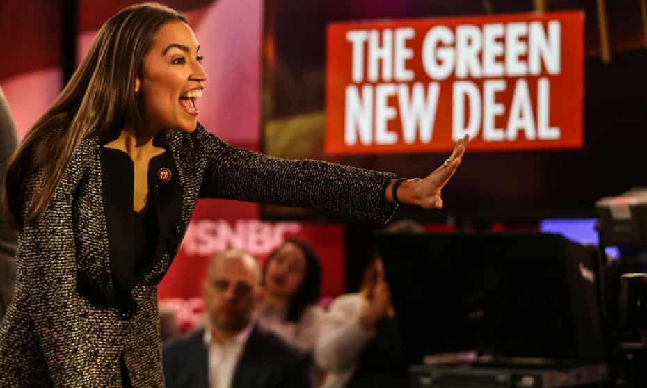 Alexandria Ocasio-Cortez greets the audience at a televised town hall event on the Green New Deal in the Bronx.