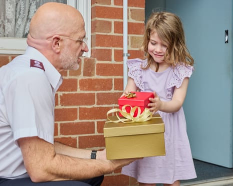 Salvation Officer handing presents to a child in need