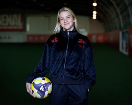 Alessia Russo astatine Arsenal’s London Colney training ground, leaning connected a reddish wall pinch a ample Arsenal logo down her