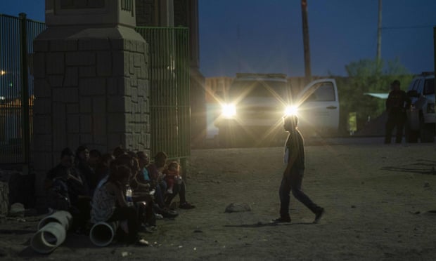 Migrants wait to be taken to a processing facility in El Paso, Texas in May.