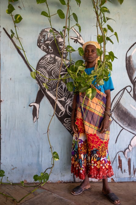 a woman stands in front of a mural