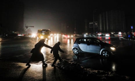 People cross a dark street in Kyiv on Thursday