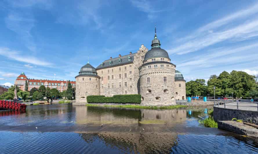 Orebro castle reflecting in water on sunny summer day in city Orebro, Sweden
