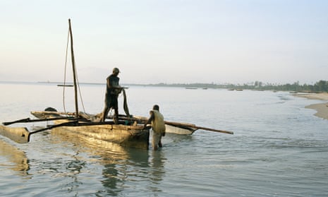 Positive African man and little boy standing near river and