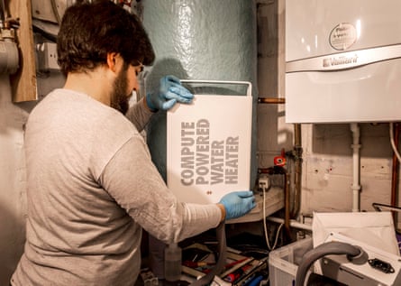 A man wearing gloves holds a heata unit he is about to install in a home