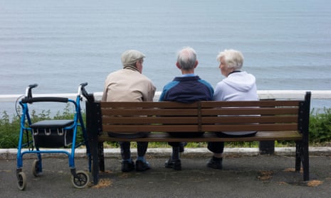 Three older people on seaside bench
