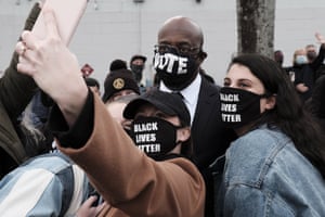 Raphael Warnock poses for a selfie with supporters after speaking at a rally in Atlanta.