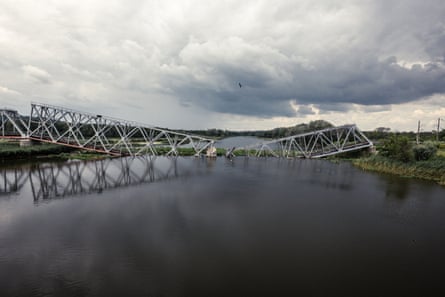 A destroyed railway bridge has collapsed into a river