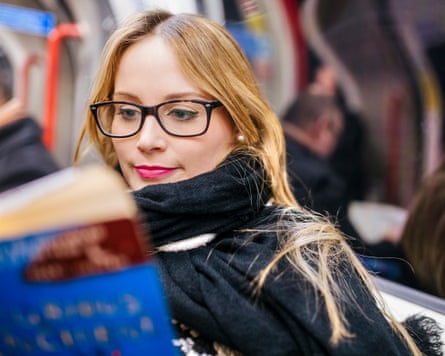Young woman reading a book on the tube
