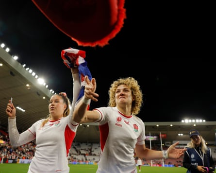 Jess Breach and Ellie Kildunne of England throw back flags and hats they have signed on their lap of honour after the Women’s Rugby World Cup 2025 Group A match between England and USA.