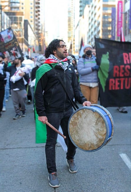 a man holds a drum during a protest