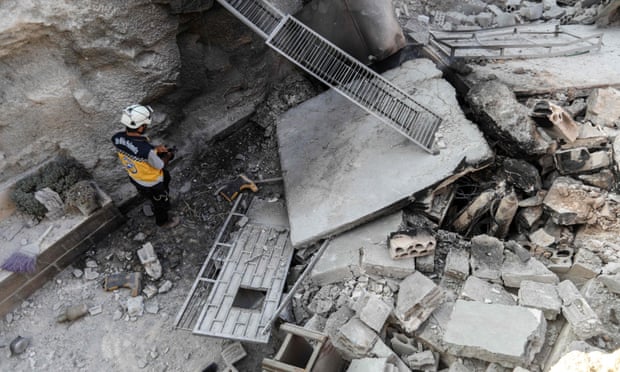 A member of the Syrian Civil Defence, also known as the ‘White Helmets’, walks through the wreckage of their centre, destroyed by regime bombing. 