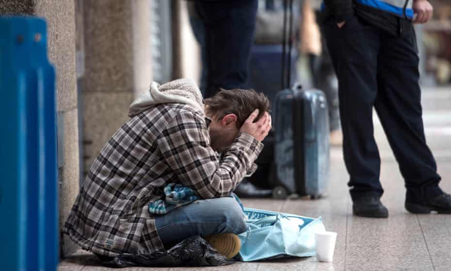 A homeless man begs in a London street