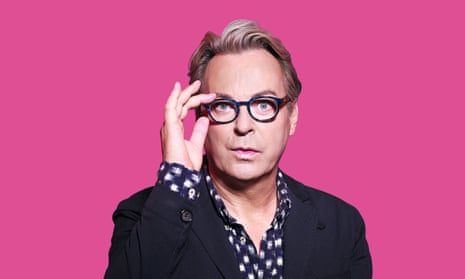 Head shot of Julian Clary with pink background