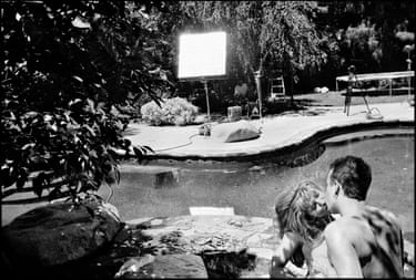 A couple kisses by a pool on the set of a pornographic film shoot