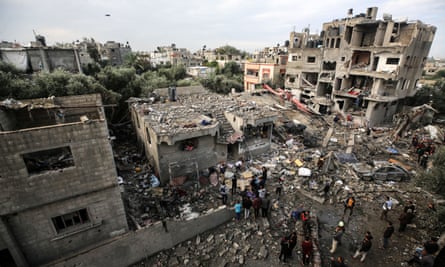 Palestinians searching for survivors following Israeli strikes on the al-Maghazi refugee camp in the central Gaza Strip on 25 December