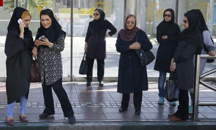 Women wait for a bus in central Tehran.