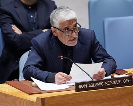 A man speaks into microphone while seated at a desk