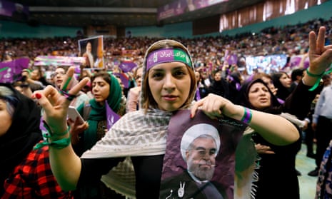 A supporter of presidential candidate Hassan Rouhani holds up his portrait during a campaign rally in Tehran on Saturday