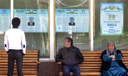 People look at election posters of presidential candidates in Tashkent in March.