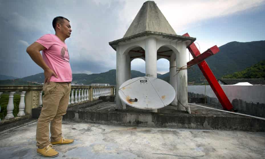 A lay leader on a church roof after government workers cut down the building’s cross in Zhejiang province. 