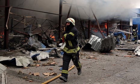 A firefighter tries to extinguish a fire that broke out in a steel warehouse following a Russian strike in Kharkiv