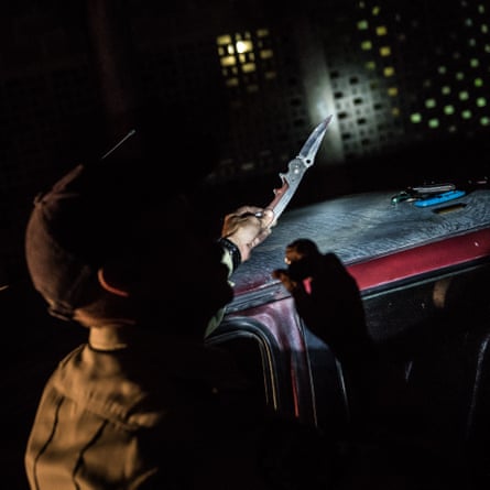 A policeman confiscates a knife during a night patrol