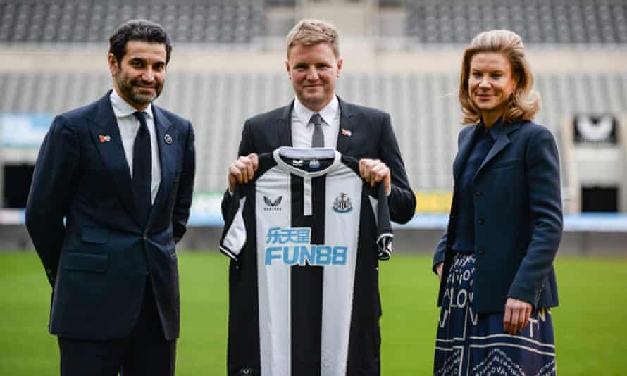 Eddie Howe poses holding a home shirt with Amanda Staveley and Mehrdad Ghodoussi